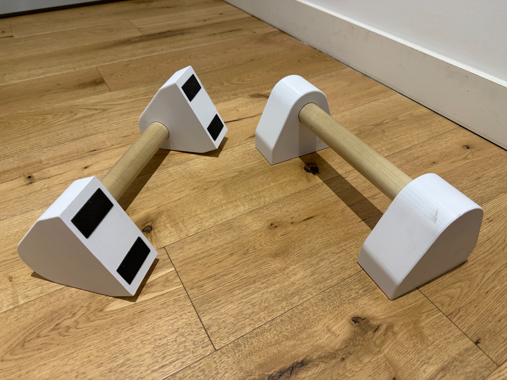 Completed 3D-printed parallettes with rubber grip feet and wood handles