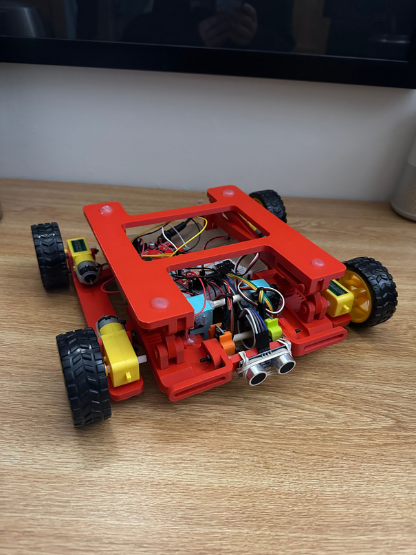 The finished autonomous mobile robot with its red 3D-printed frame and scissor lift