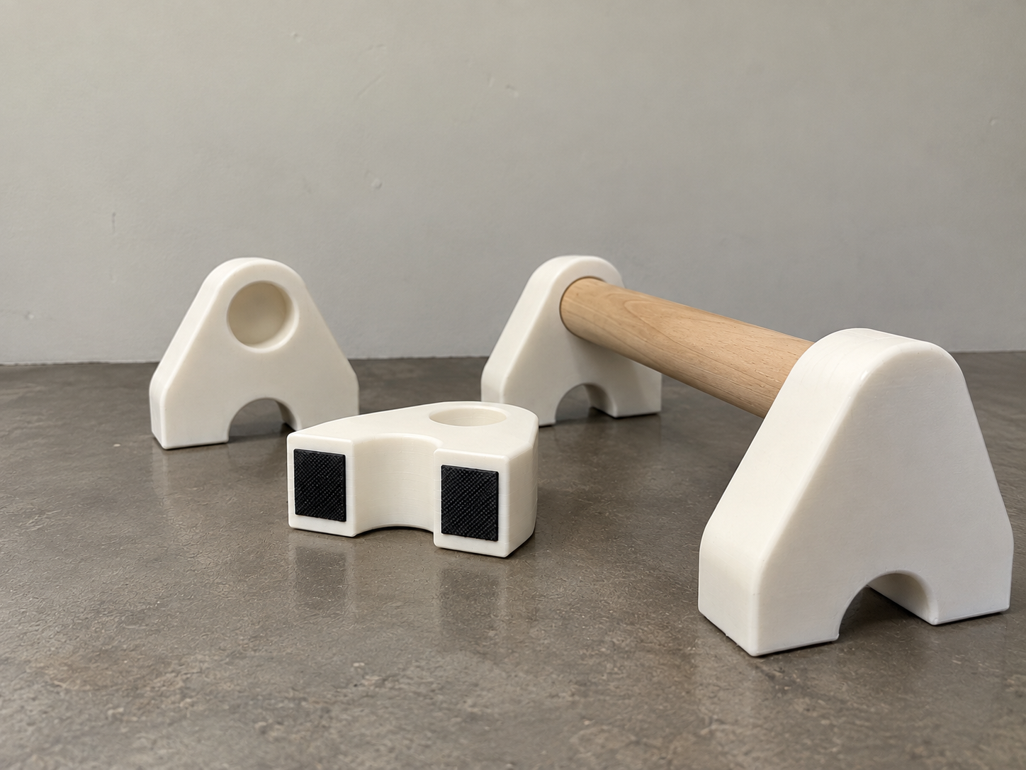 White 3D-printed modular parallettes with a wooden handle